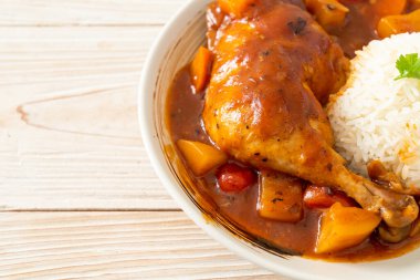 Domatesli ev yapımı tavuk güveci, soğan, havuç ve patates tabakta pilav.