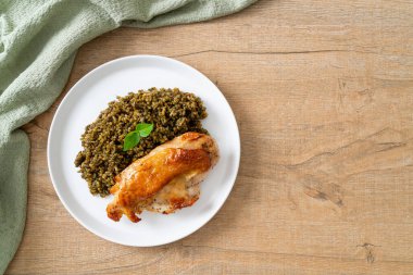 Kızarmış pesto pilavı ve beyaz tabakta kızarmış tavuk.