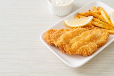 balık ve patates kızartması - kızarmış balık fileto patates cipsi ve limonlu beyaz tabak