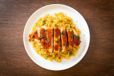 Izgara tatlı ve acılı tavuk ve tabakta körili pilav.