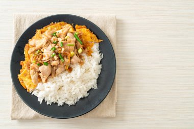 Pirinç üzerine sarımsak ve yumurta soslu kızarmış domuz eti. Asya usulü.