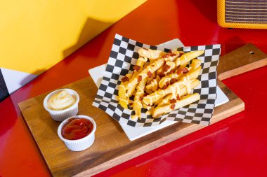 Peynirli patates kızartması ve kızarmış domuz pastırması.