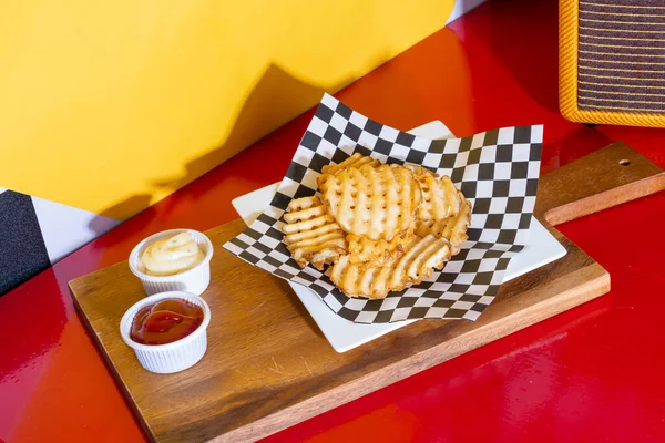waffle fries with ketchup and mayonnaise - American food style