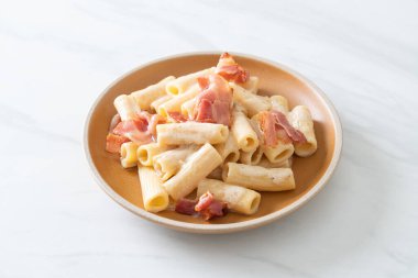 Beyaz soslu ve pastırmalı ev yapımı spagetti rigatoni makarna. İtalyan usulü.