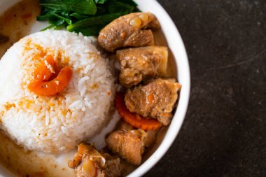 Beyaz tabakta pilav ve domuz pirzolası.