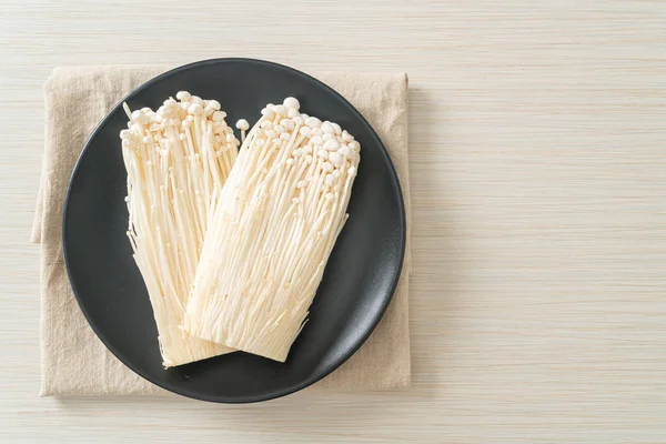 fresh enoki mushroom or golden needle mushrooms on plate