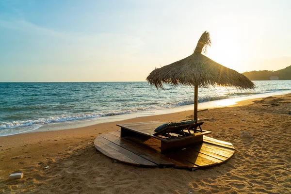 beach chair and umbrella with sea beach background at sunset time - Holidays and vacation concept