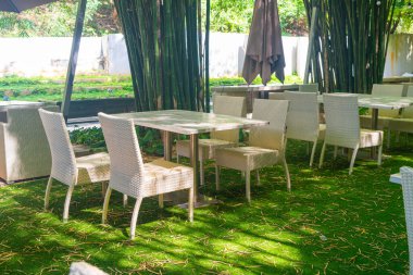 Boş hasır masa ve sandalye bambu bahçesi olan açık hava restoranında.
