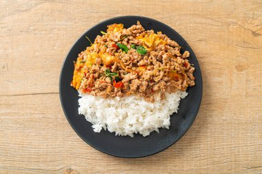 Pirinçli yumurta ve fesleğenli kızarmış domuz eti. Asya usulü.