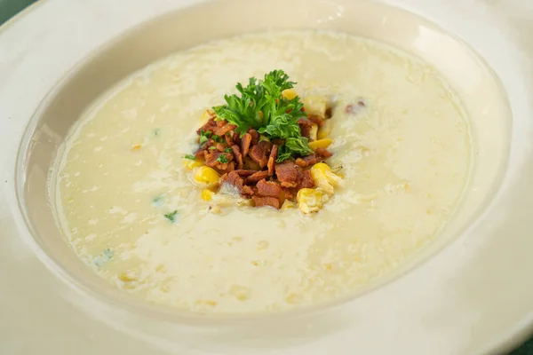 corn soup with crispy bacon on plate