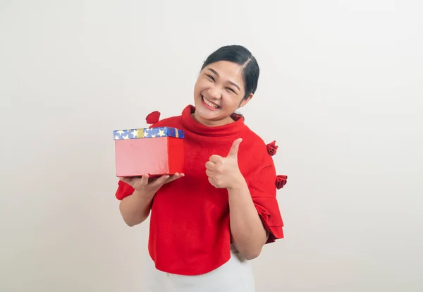 portrait happy Asian woman wearing red shirt with gift box on hand for Christmas festival