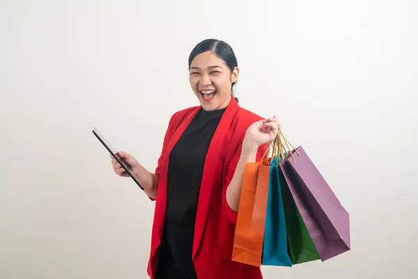 白い背景を持つ手にショッピングバッグやタブレットを持つアジアの女性 — ストック写真