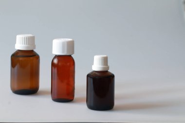 Tıbbi amaçlar için çeşitli boyutlarda cam şişeler, tabletler ve şerbetler.