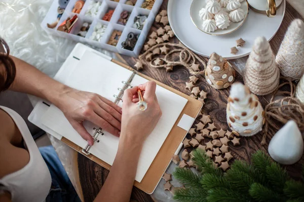 stock image Top view of young woman is writing goals for New Year 2021 on diary on desk with Christmas Tree