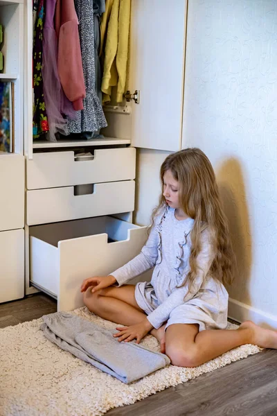 Девочка-подросток свернула одежду по методу Мари Кондос. Размещение одежды в шкафу — стоковое фото