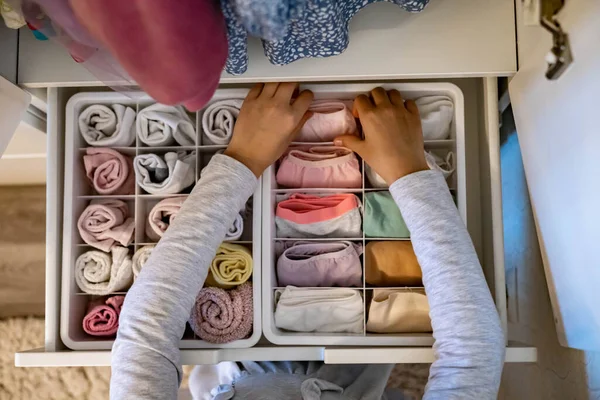 As mãos femininas que organizam o armazenamento de meias de roupa interior t-shirts usam o método Marie Kondos. Perfeccionista adolescente menina — Fotografia de Stock