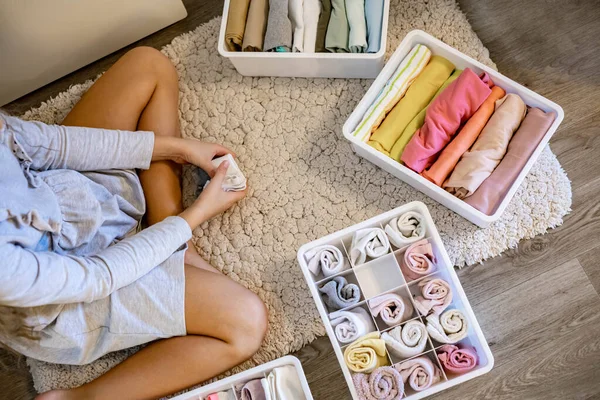 Chica adolescente enrollado ropa utilizar método Marie Kondos. Colocar ropa en el armario — Foto de Stock