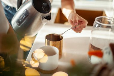 Genç, güzel bir anne ve ağlayan bir kız şık bir ev mutfağında kakao hazırlıyorlar..