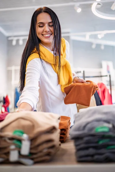 Modern woman choosing clothes at fashionable store boutique discount enjoying leisure hobby