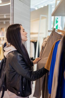 Modern kadın şık mağaza butik indiriminde kıyafet seçiyor. Boş zamanların zevkini çıkarıyor.
