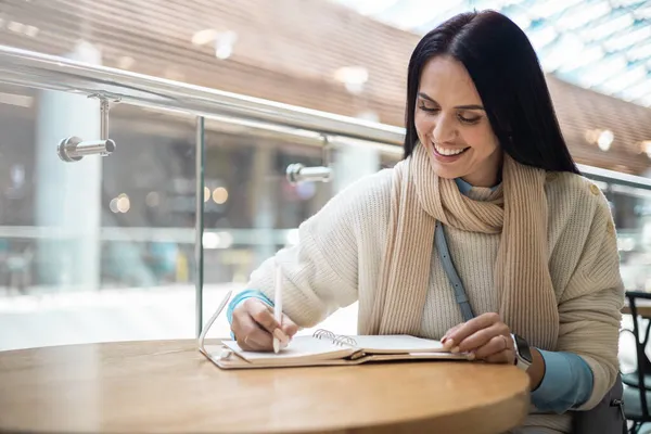 Usmívající se obchodní žena psaní papíru seznam poznámek v nákupním středisku mají pozitivní emoce — Stock fotografie