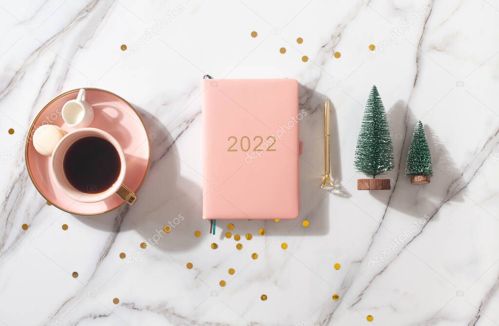 Flat lay composition with New Years decoration, coral colored 2021 diary book and coffee cup