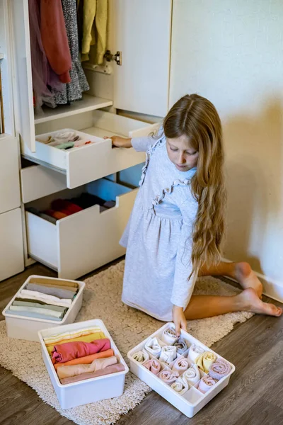Девочка-подросток свернула одежду по методу Мари Кондос. Размещение одежды в шкафу — стоковое фото