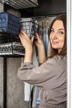 Kadın ev hanımı mevsimlik gardırop temizliği yapıyor. Konmari 'nin havlularını yerleştiriyor.