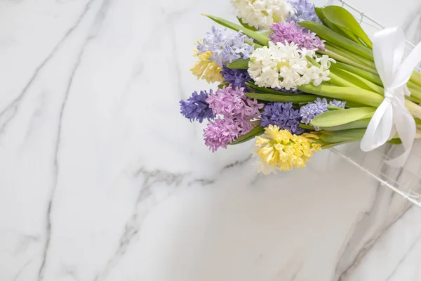 Blumenstrauß aus frühlingshaften Blüten von Hyazinthen. Hintergrund aus weißem Marmor. — Stockfoto