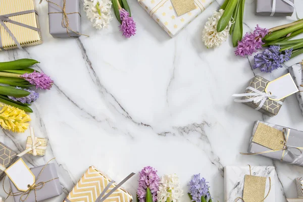 Top view trendi kompozíció ünnepi csomagolt ajándékdobozok szalag íj díszített virágos virágok — Stock Fotó