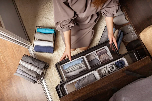 Huisvrouw handen met netjes gezet ondergoed, kleding en accessoires moderne garderobe organisatie — Stockfoto