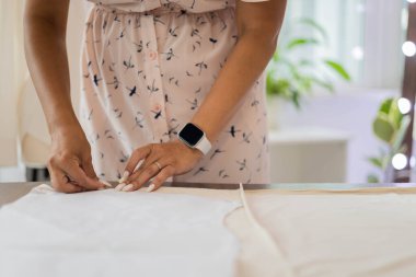 Mutlu terzi kadın moda kıyafetleri yaratmak için dikiş ve mezura kullanır.