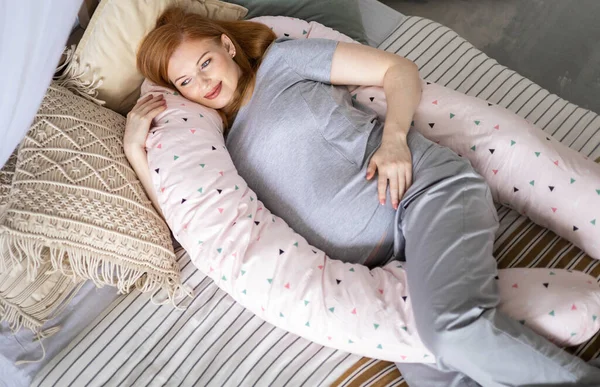 Visão superior futura mãe feliz deitada na cama confortável abraçando travesseiro para relaxar grávida — Fotografia de Stock