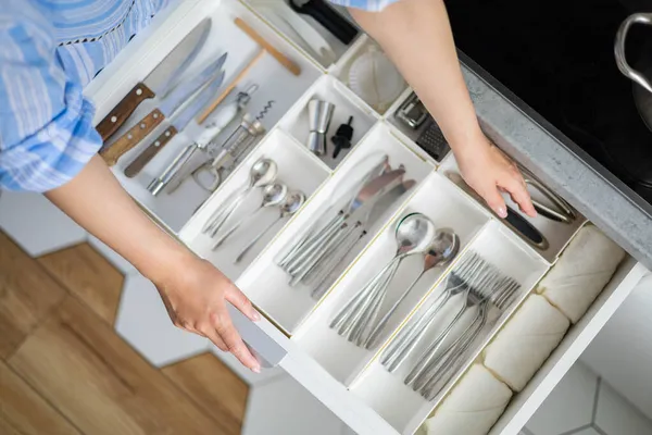 Top view closeup housewife hands tidying up cutlery in drawer general cleaning at kitchen — Stock Photo, Image