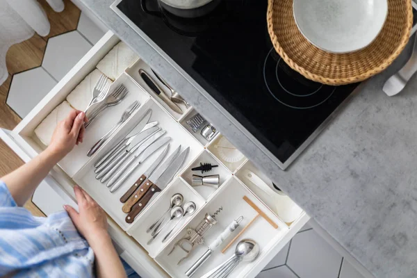 Top view closeup housewife hands tidying up cutlery in drawer general cleaning at kitchen — Stock Photo, Image
