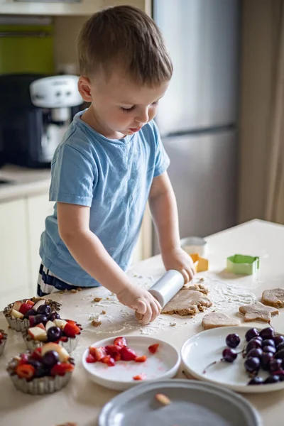 stock image Cheerful male baby cooking homemade summer dessert with fruits and berries at home kitchen