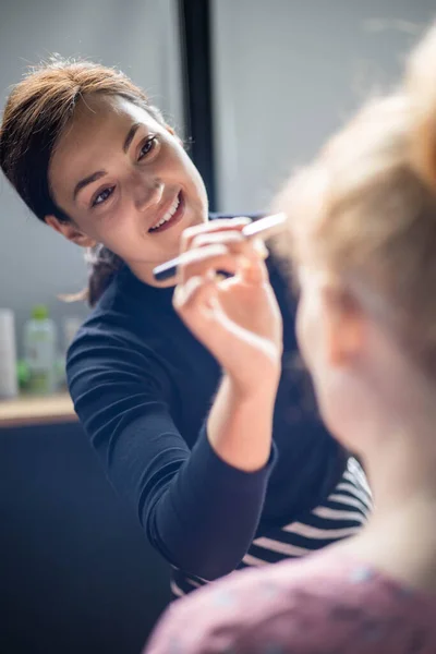 Mulher visagista aplicando maquiagem cosmética para a mulher grávida se preparando. Maquiagem artista trabalhando — Fotografia de Stock