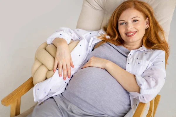 Top view ευτυχισμένη νεαρή κοκκινομάλλα έγκυος γυναίκα ξαπλωμένη σε άνετη πολυθρόνα — Φωτογραφία Αρχείου