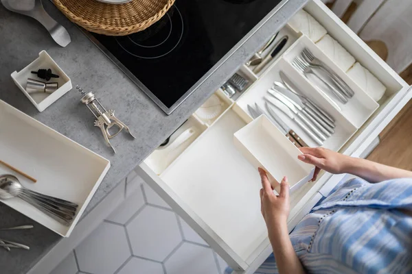 Primeros planos manos femeninas cuidadosamente ensamblando cubiertos en cajas de almacenamiento pp en el cajón de la cocina minimalista —  Fotos de Stock