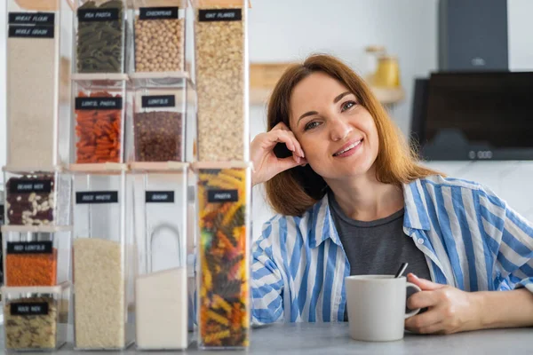 Organizador de espacio profesional mujer sonriendo posando con cajas de cartón para un cómodo almacenamiento de productos —  Fotos de Stock