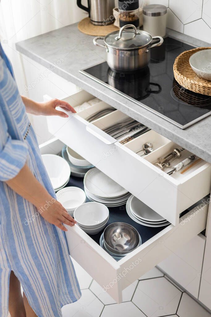 Top view modern housewife tidying up kitchen cupboard during general cleaning or tidying up