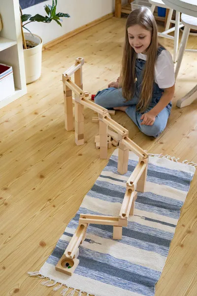 Tiener meisje spelen track constructor blok toren met metalen bal Maria Montessori materialen — Stockfoto