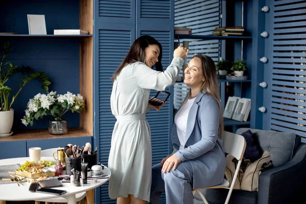美容室で働くモデルフェイス使用ブラシに化粧品を適用するプロの女性化粧アーティスト — ストック写真
