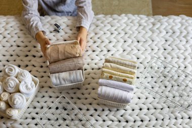 Kadın elleri düzgünce katlanmış çarşaflar ve havlular yapışkan etiketli Marie Kondo metodunu kullanıyor
