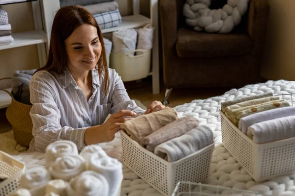 Mulher perfeitamente dobrado lençóis e toalhas usar método Marie Kondo com etiquetas etiqueta pegajosa — Fotografia de Stock