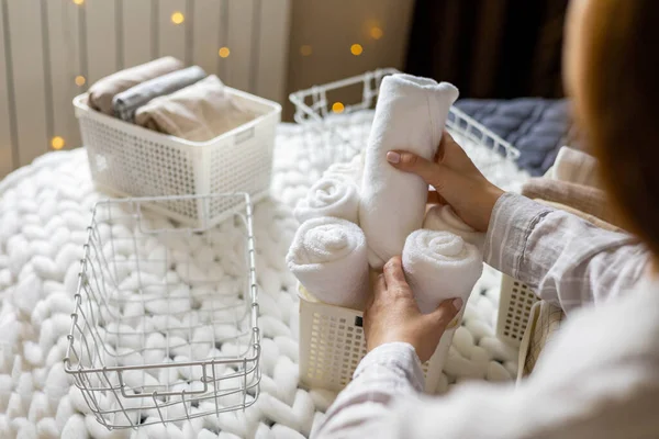 Ama de casa moderna poniendo toallas cuidadosamente dobladas, fundas de almohada, fundas nórdicas en una caja metálica de plástico —  Fotos de Stock
