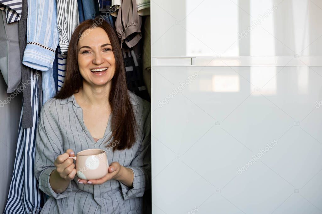 Portrait happy domestic woman posing wardrobe storage organization. Wooden furniture cabinet design