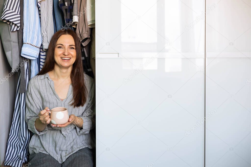 Portrait happy domestic woman posing wardrobe storage organization. Wooden furniture cabinet design