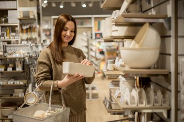 Mutlu ev hanımı, ahşap kapaklı yiyecek depolama konforlu eko dostu seramik çanta seçiyor.