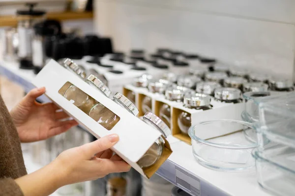Primo piano mani femminili che tengono vaso di vetro con coperchio in metallo per l'organizzazione spazio di archiviazione spezie cucina — Foto Stock
